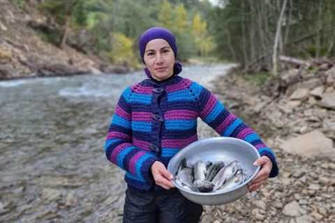 A WOMAN LIVES IN THE MOUNTAINS. COOKING TROUT FISH