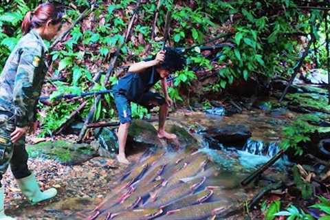 girl and boy catching fish cooking in the forest.