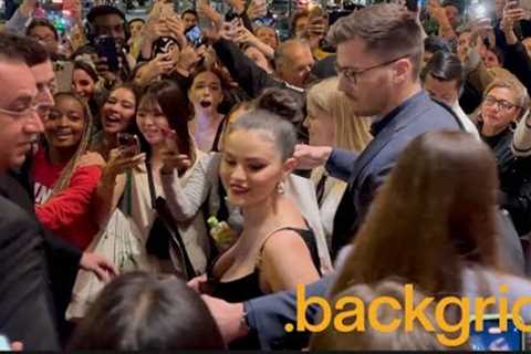 Selena Gomez navigates through a sea of fans as she leaves her hotel during Paris Fashion Week