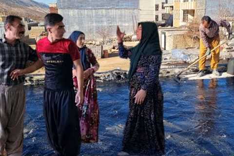 Abbas, with the help of his father, tarred the roof of the warehouse to prevent rain.