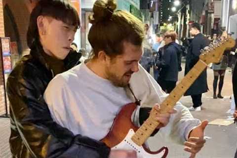 Street performer surprised by guitarist passing by in Korea