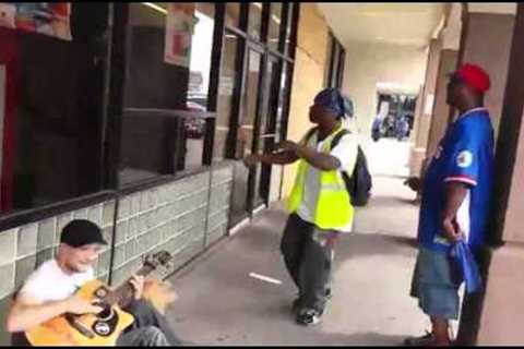A Man Playing Guitar Is Joined By Two Strangers In An Impromptu Street Performance.